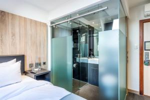 格拉斯哥格拉斯哥Z酒店的一间卧室设有一张床和一个玻璃淋浴间