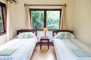 ChiawaKiambi Safaris Lodge的带窗户的客房内的两张床