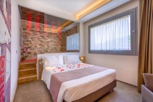 乌尔巴尼亚Boutique Hotel Bramante & SPA的一间卧室设有一张床和砖墙