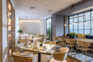 海若克利欧DOM Boutique Hotel的餐厅设有桌椅和窗户。