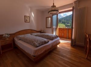 摩德纳迪-坎皮格里奥克里奇奥多洛米蒂酒店的一间卧室设有一张床和一个大窗户