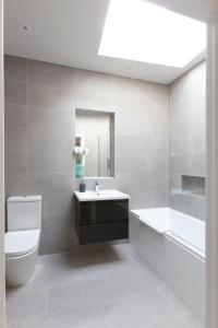 温莎Hampden Apartments - The Richard的浴室配有卫生间、盥洗盆和浴缸。