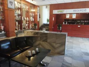 塔塔班亚Sport Hotel的一间商店里的酒吧,里面设有真皮沙发和桌子