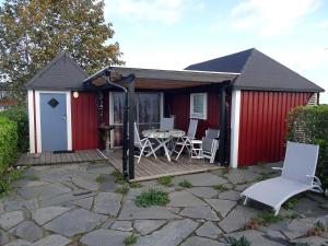 比克瑟尔克鲁克1C, Första parkett, 50m till badstrand的庭院里设有红色的棚子,配有桌椅