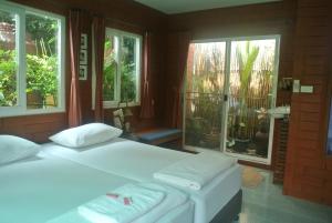 北碧PY旅馆的一间卧室设有两张床和两个窗户。