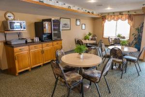 Meadow LakeWoodland Inn的一间带桌椅的用餐室和一间厨房