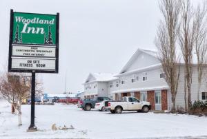 Meadow LakeWoodland Inn的雪地林地旅馆标志