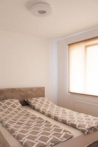 萨拉热窝Apartment Otoka Sarajevo的白色客房的一张床位,设有窗户