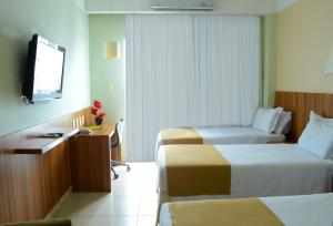 阿拉卡茹里尔经典酒店的酒店客房设有两张床和一台平面电视。
