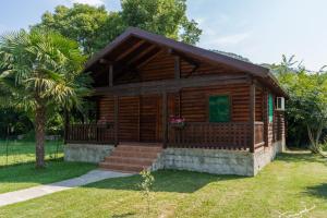 PonariWooden Village Resort的小木屋设有门廊和棕榈树