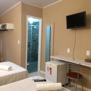 瓜皮米林Pousada Nascente Pequena的客房设有两张床和一台墙上的电视。