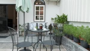 曼谷内维尤尊贵公寓：拉查达的种有植物的庭院里的桌椅