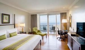 长滩岛安可纳度假酒店的酒店客房配有一张床、一张书桌和一台电视。