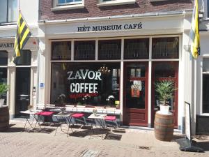 斯希丹B&B Museumkwartier Schiedam的咖啡馆前的商店,有桌椅