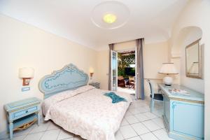 伊斯基亚Villa Formica的卧室配有1张床、1张桌子和1张镜子