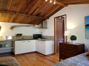 菲加里Caseddu Di Poggiale的厨房配有白色橱柜和木制天花板