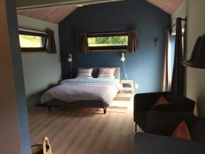 杜柏L'atelier的一间卧室配有一张床、一张沙发和两个窗户。