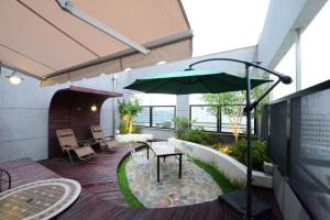 大田邓桑灰调酒店的一个带桌子和遮阳伞的庭院