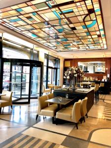 里尔欧洲里尔装饰艺术酒店的大堂设有带桌椅的餐厅