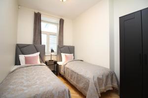 塔林Tallinn City Apartments 4 bedroom with sauna and 2 bathroom的一间卧室设有两张床和窗户。