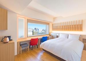 函馆HOTEL＆SPA CENTURY MARINA HAKODATE的一间卧室配有一张床、一张书桌和一个窗户。