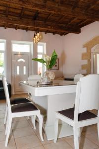 阿尔梅尼Diogenis Residence Euphoria的一间配备有白色桌椅的用餐室