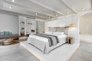 阿达玛斯Arco Solium Suites的白色的卧室设有一张大床和一间浴室。