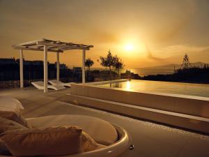 米克诺斯城Arcs Boutique Villa Hotel的屋顶上的热水浴池,享有日落美景