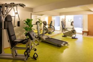 屈伊朗Hotel La Chaumière的健身房,配有跑步机和有氧运动器材