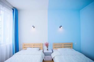 桂林Murphy Youth Hostel Guilin的蓝色墙壁客房的两张床