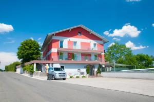 SierningGasthof Alpenblick的停在红白房子前面的卡车