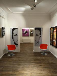 不莱梅artHOTEL Bremen的一间房间,墙上挂着两张红色椅子和照片