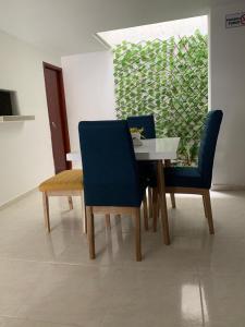 里奥阿查Hotel Atardecer Guajiro的一间带桌子和两把蓝色椅子的用餐室