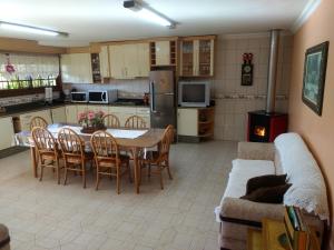 本图贡萨尔维斯Casa das Palmeiras + Quiosque的厨房以及带桌子和沙发的客厅。