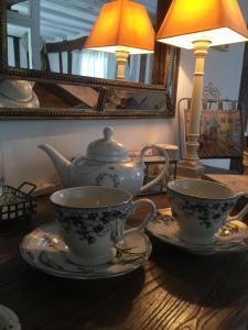 加尼百子莲住宿加早餐旅馆的一张木桌,上面有2个茶杯和一盏灯