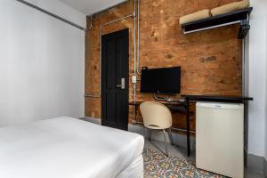 里约热内卢蒙特卡斯特罗酒店的一间卧室配有一张床和一张带电脑的书桌