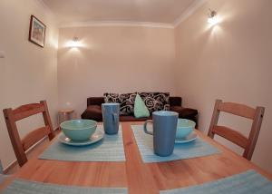乌斯特卡Apartamenty Tercet, Apartament Kwartet, Apartament DUO的餐桌上放着两个杯子和碗