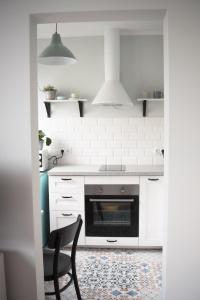 什切青TS Budget Stay的厨房配有白色橱柜和黑烤箱。