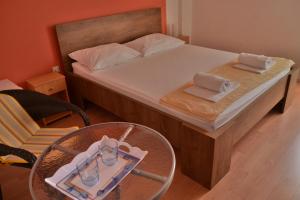帕格Villa Galeb Pag - at the main Beach的小卧室配有一张带桌子和眼镜的床