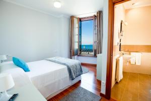 巴约讷Apartamentos Villa Zoila Baiona的一间卧室配有一张床,享有海景