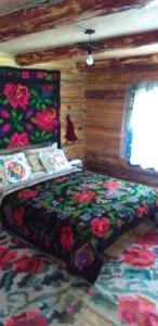 上维谢乌Pensiunea Anita的一间卧室配有一张带彩色床罩的床