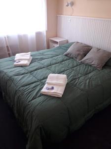 蒙特格兰德Danny ap - Amplio y cómodo - 18 min Aeropuerto - Zona de Restos - Parking的一间卧室,在绿床上配有2条毛巾