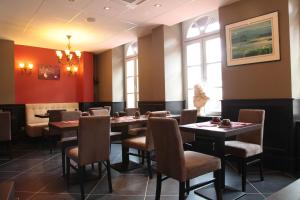 贝桑松沃邦酒店的用餐室设有桌椅和窗户。