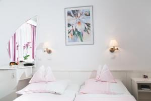 凯奇凯梅特费边潘兹欧酒店的配有白色墙壁和粉红色枕头的客房内的两张床