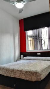 贝尼多姆Precioso Apartment Lepanto-Levante的一间卧室设有一张红色墙壁和窗户的床