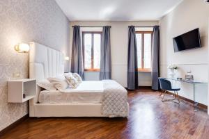 罗马Trevi Private Suites by Premium Suites Collection的一间卧室配有一张床、一张书桌和一台电视。
