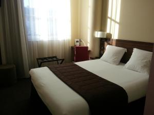 贝桑松沃邦酒店的一间卧室设有一张大床和窗户