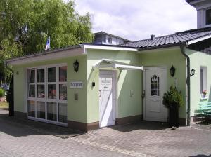 岑平Pension Dünenhaus的一座绿色和白色的小建筑,设有门
