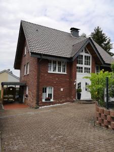 门登Ferienwohnung Menden的红砖房子,设有白色车库