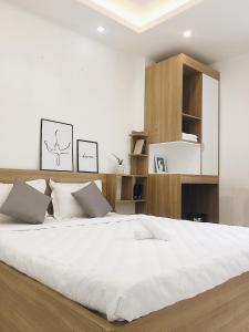 胡志明市Hello SaiGon Homestay的一间卧室配有一张带白色床单的大床